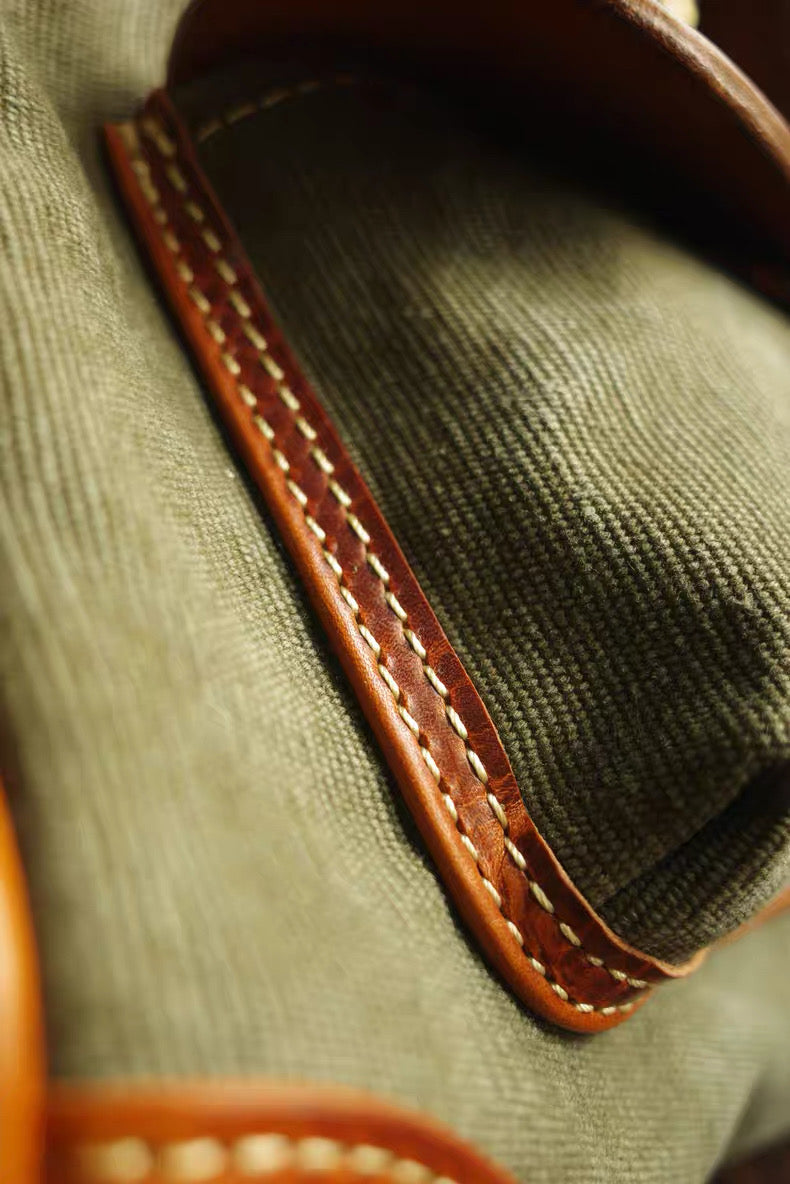 Close-up of a green fabric bag with brown leather trim