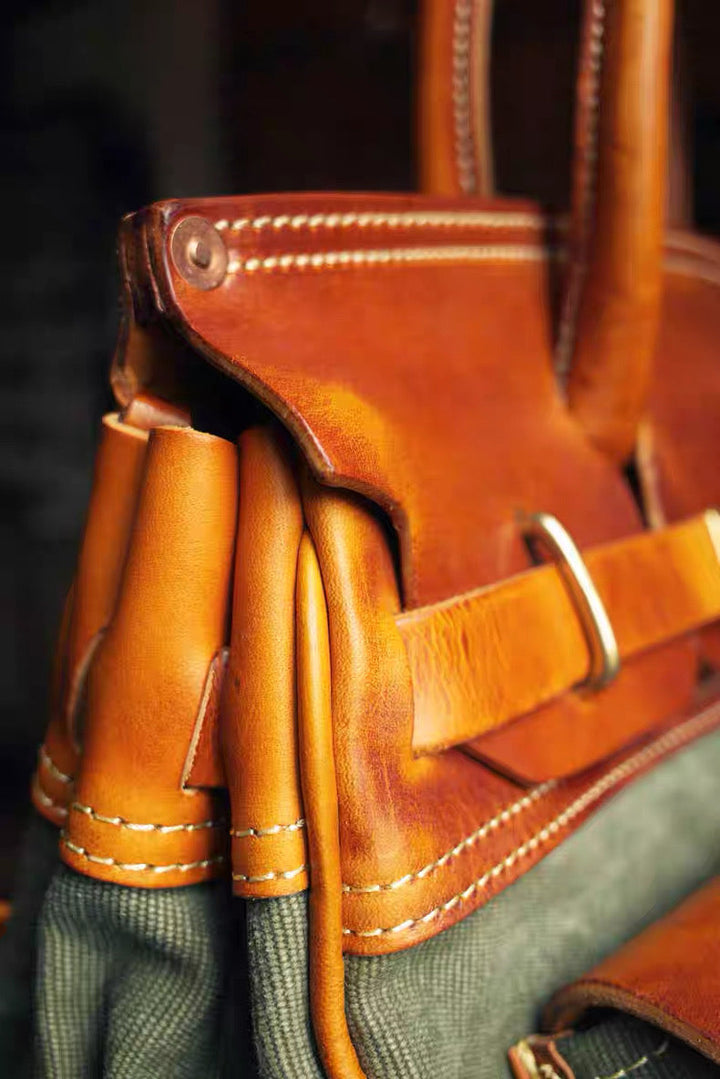Close-up of a brown leather bag with visible stitching details.