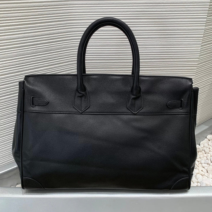 Black leather handbag on a light gray background