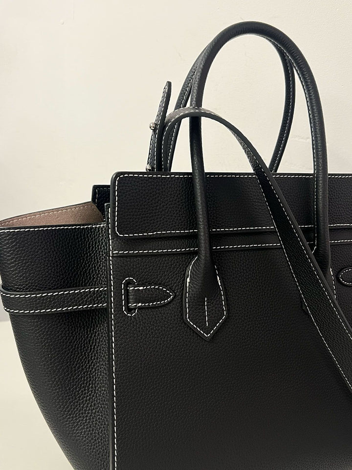 Luxury artisan woven raffia tote bag bronze hardware close up detail