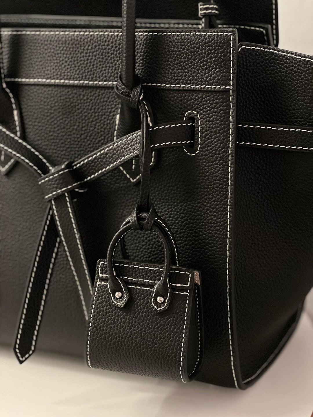 Large black raffia beach bag side view showing depth and open top silhouette