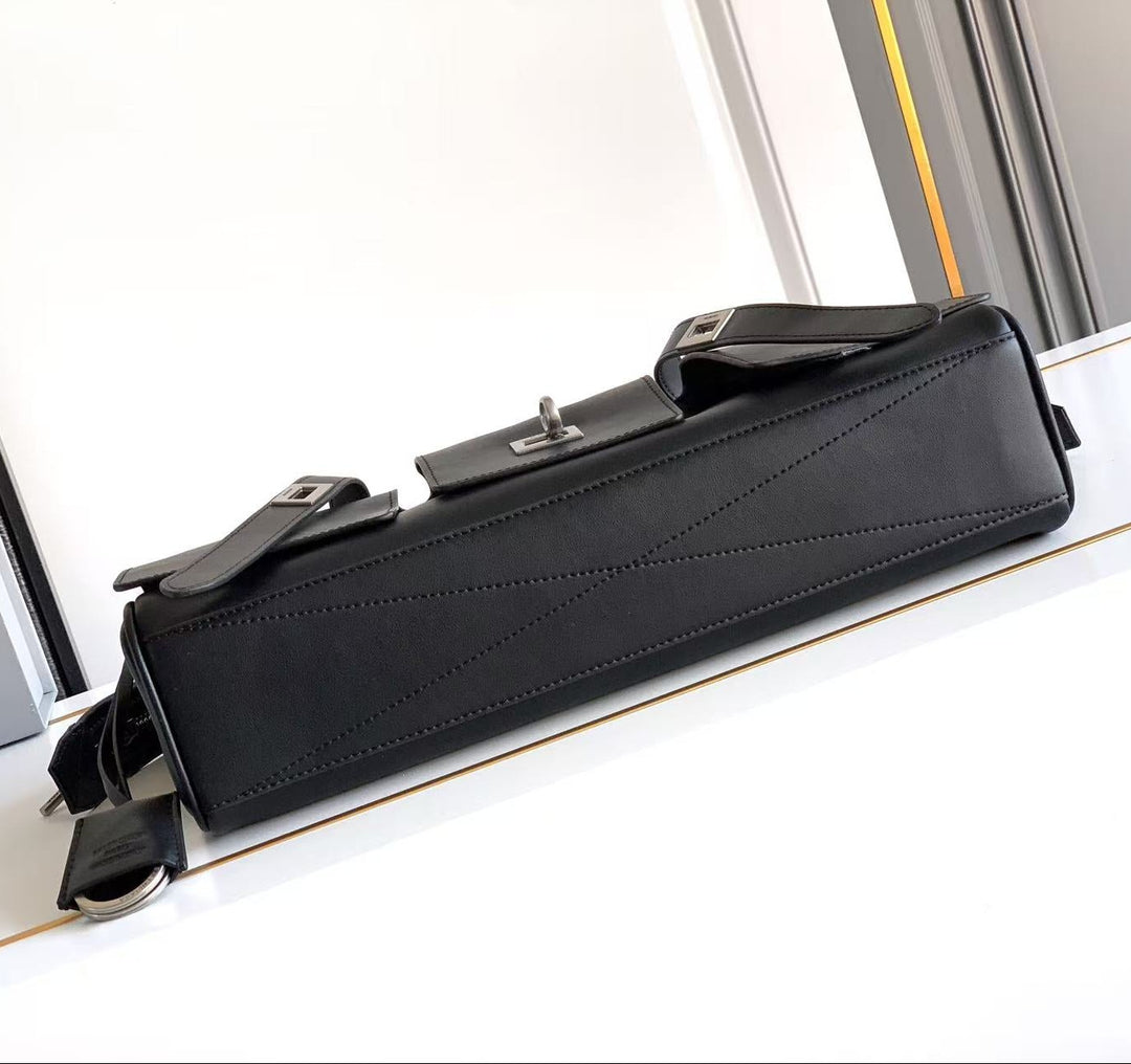 Black briefcase on a white surface with a blurred background