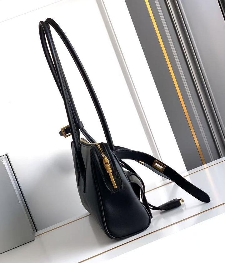 Black handbag on a white surface with a reflective background