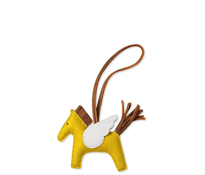Yellow horse-shaped keychain with a brown strap on a white background