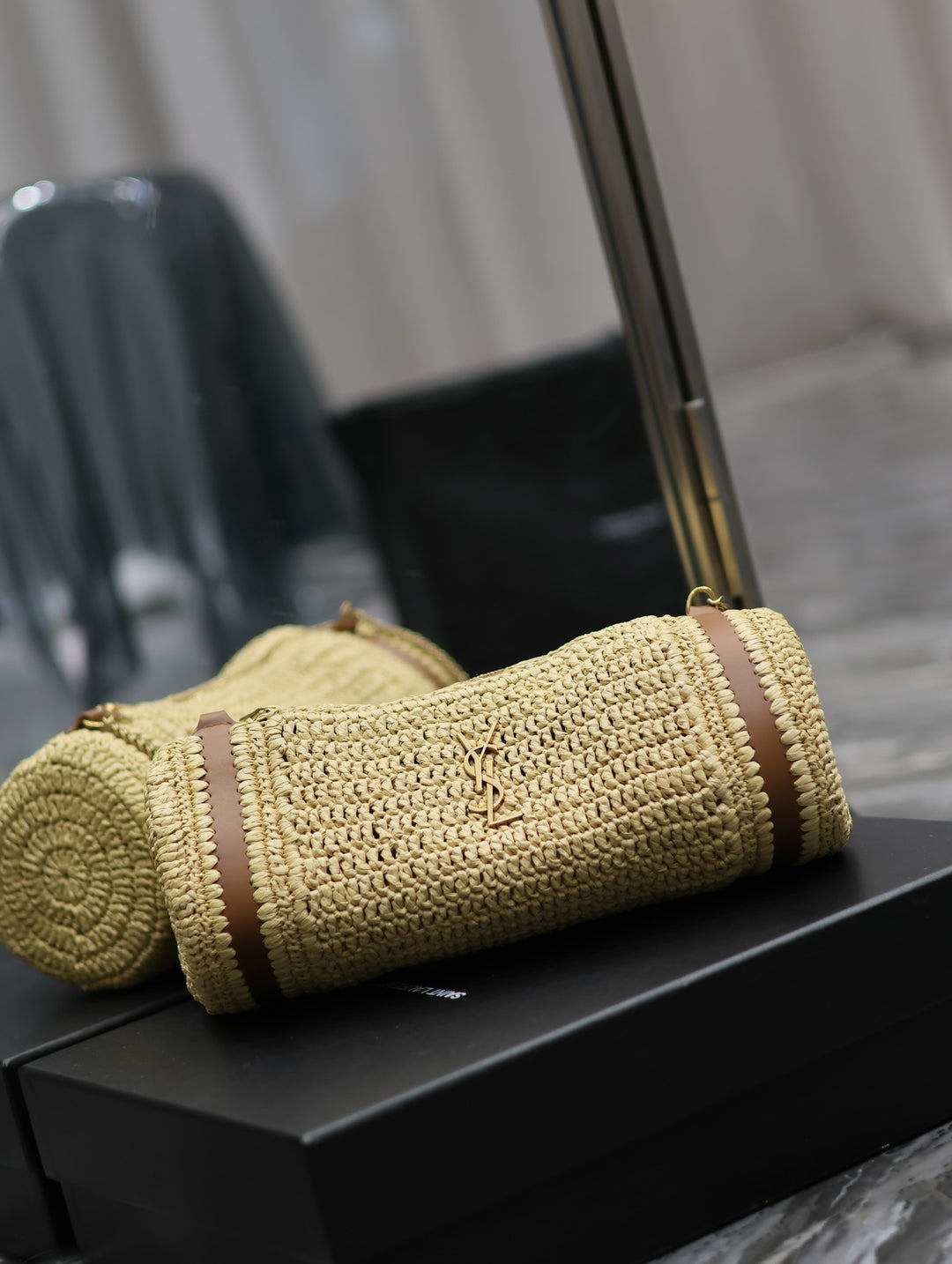Top view of raffia cylinder bag open showing zip closure track and interior access
