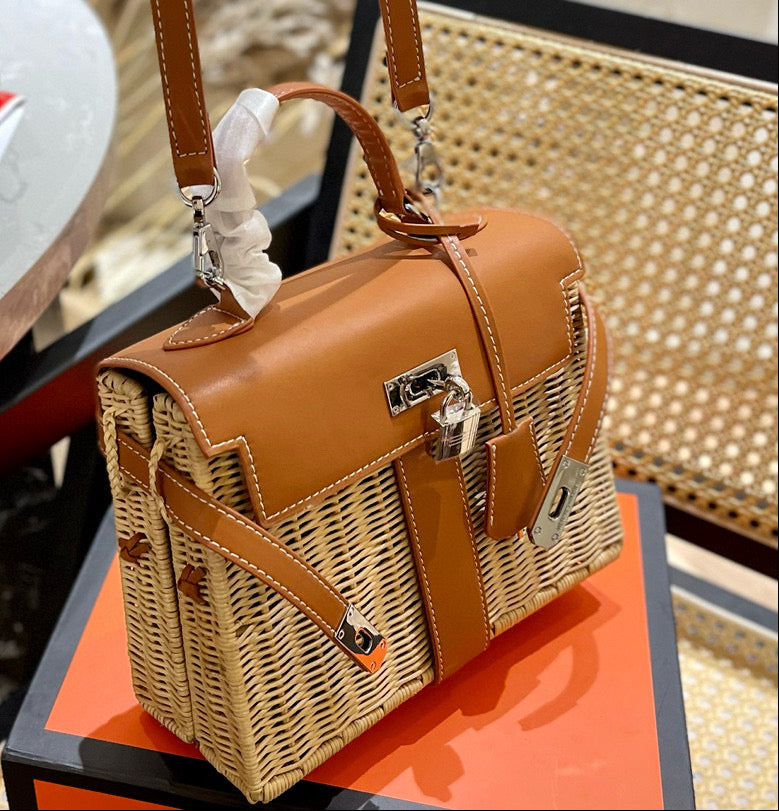 Brown wicker handbag with leather straps on a table