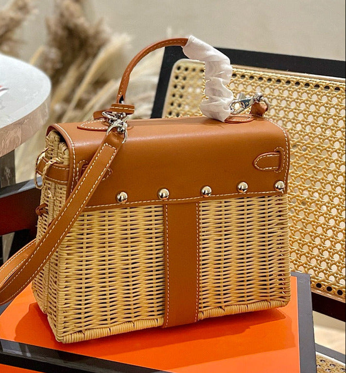 Brown wicker handbag on an orange surface with a blurred background