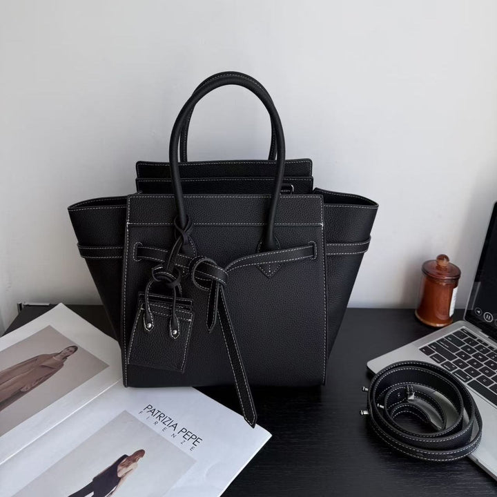 Large woven raffia luxury tote bag with attached sunglasses case on chain detail