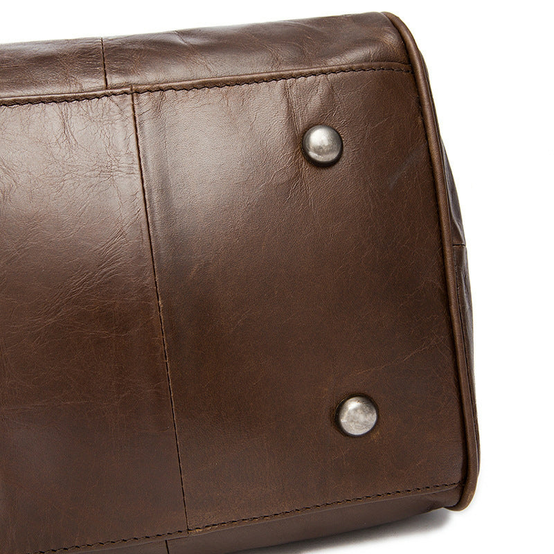 Close-up of a brown leather bag with metal studs on a white background