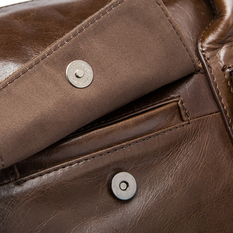 Close-up of a brown leather bag with metal buttons