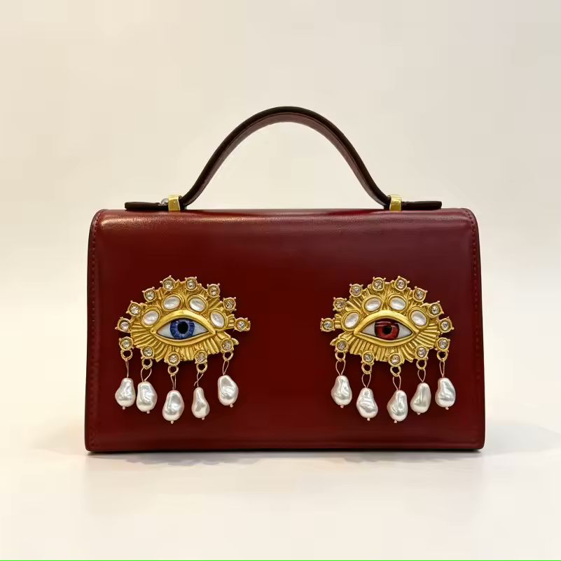 Namrico small square leather crossbody bag close-up of 3D jewel eye and decorative pearl detail