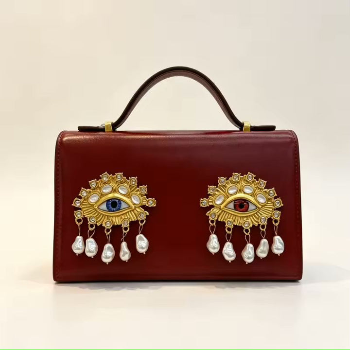 Namrico small square leather crossbody bag close-up of 3D jewel eye and decorative pearl detail