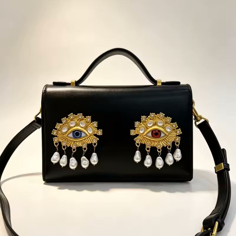 Pink jewel eye crossbody bag angle view highlighting sculptural detail and compact silhouette