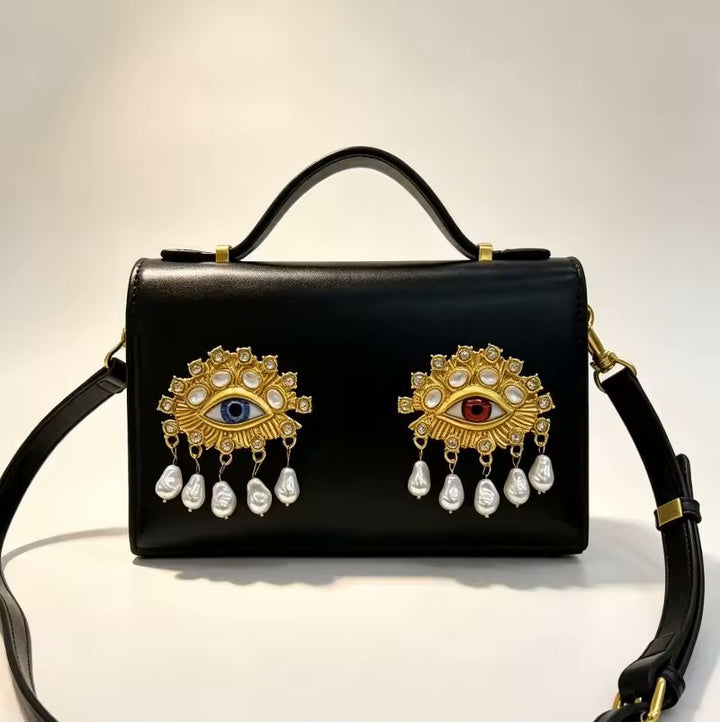 Pink jewel eye crossbody bag angle view highlighting sculptural detail and compact silhouette