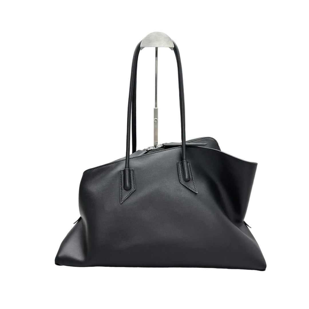 Black leather handbag on a gray textured surface with a matching background