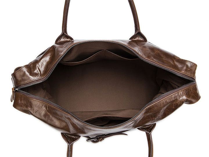 Brown leather bag with open top on a white background