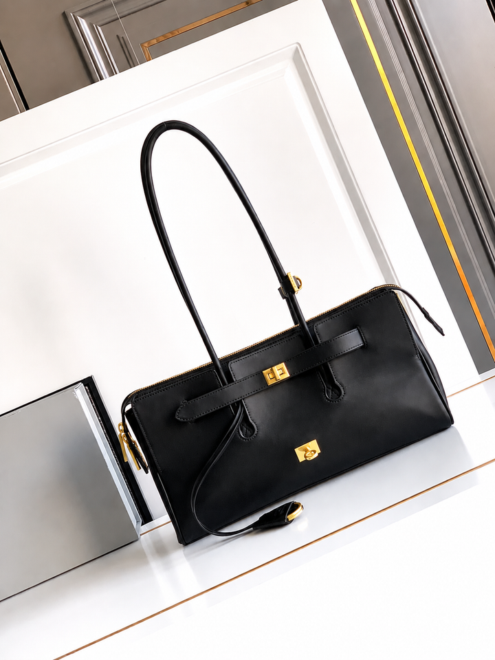 Black handbag with gold hardware on a white surface