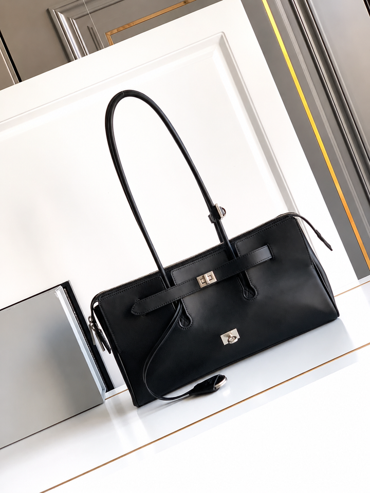 Black handbag on a white surface with a blurred background