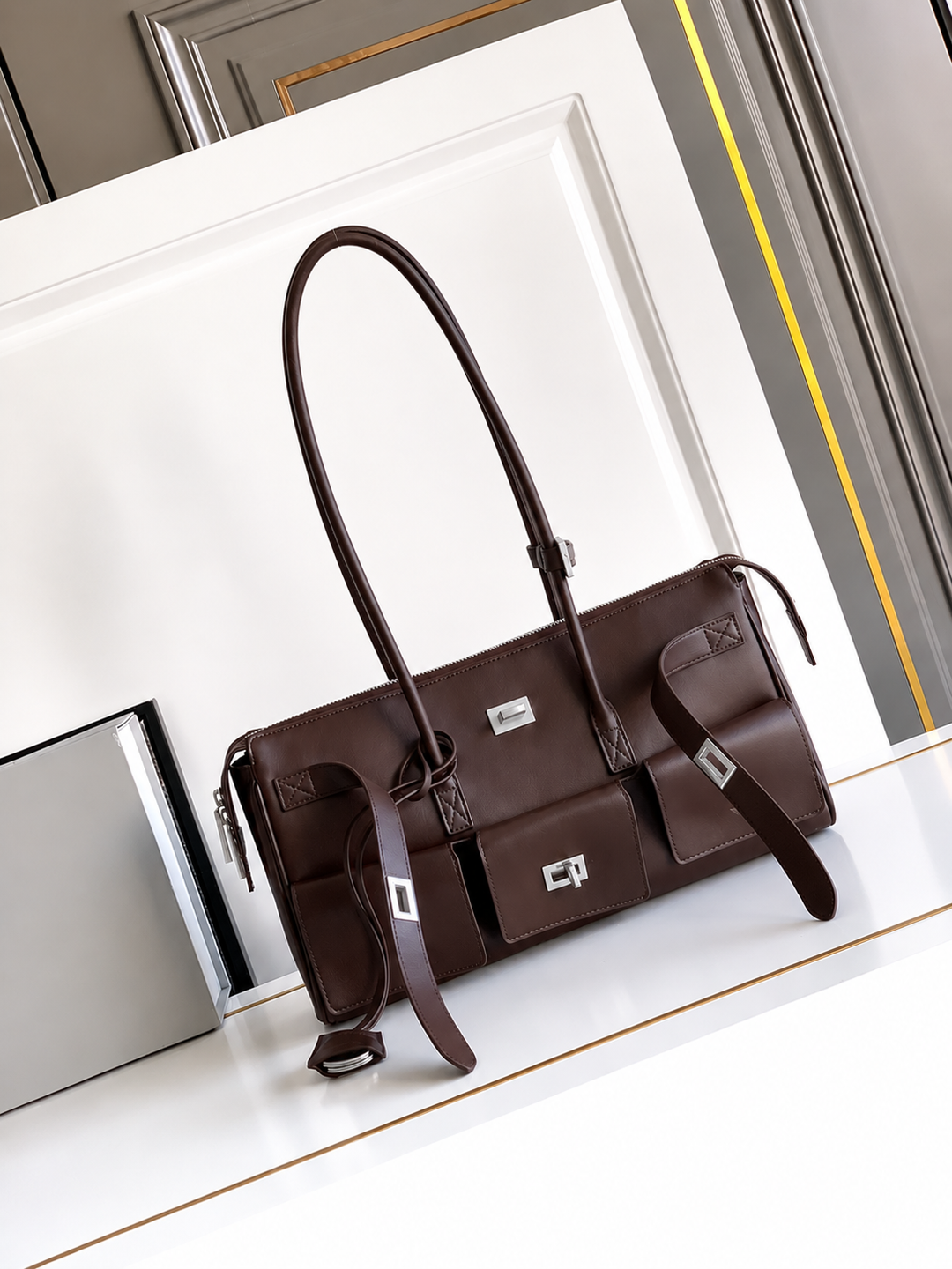 Brown leather handbag on a white surface with a blurred background
