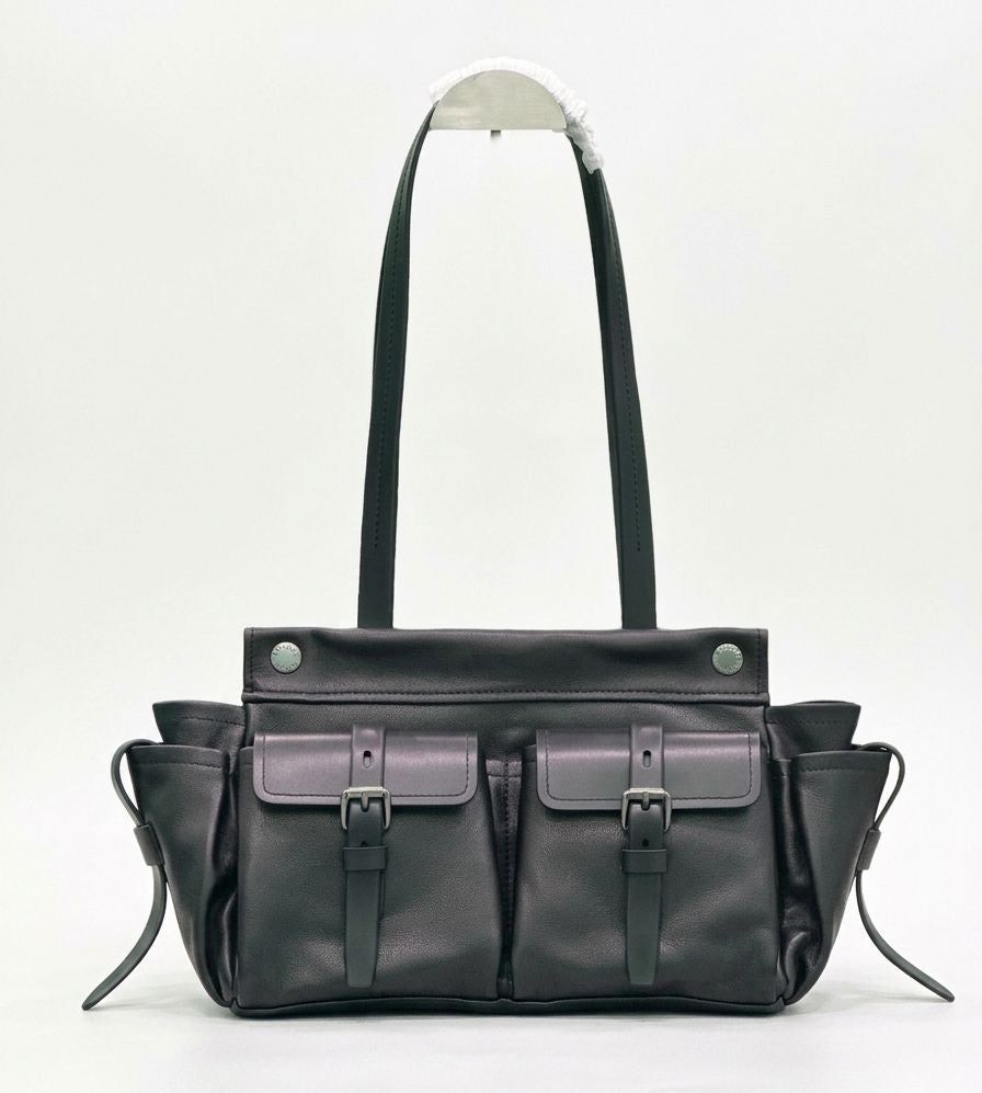 Black leather bag with multiple pockets and straps on a white background