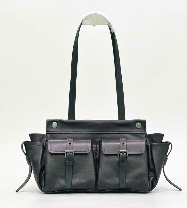 Black leather bag with multiple pockets and straps on a white background