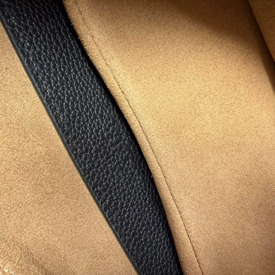 Close-up of beige fabric with a black leather strip