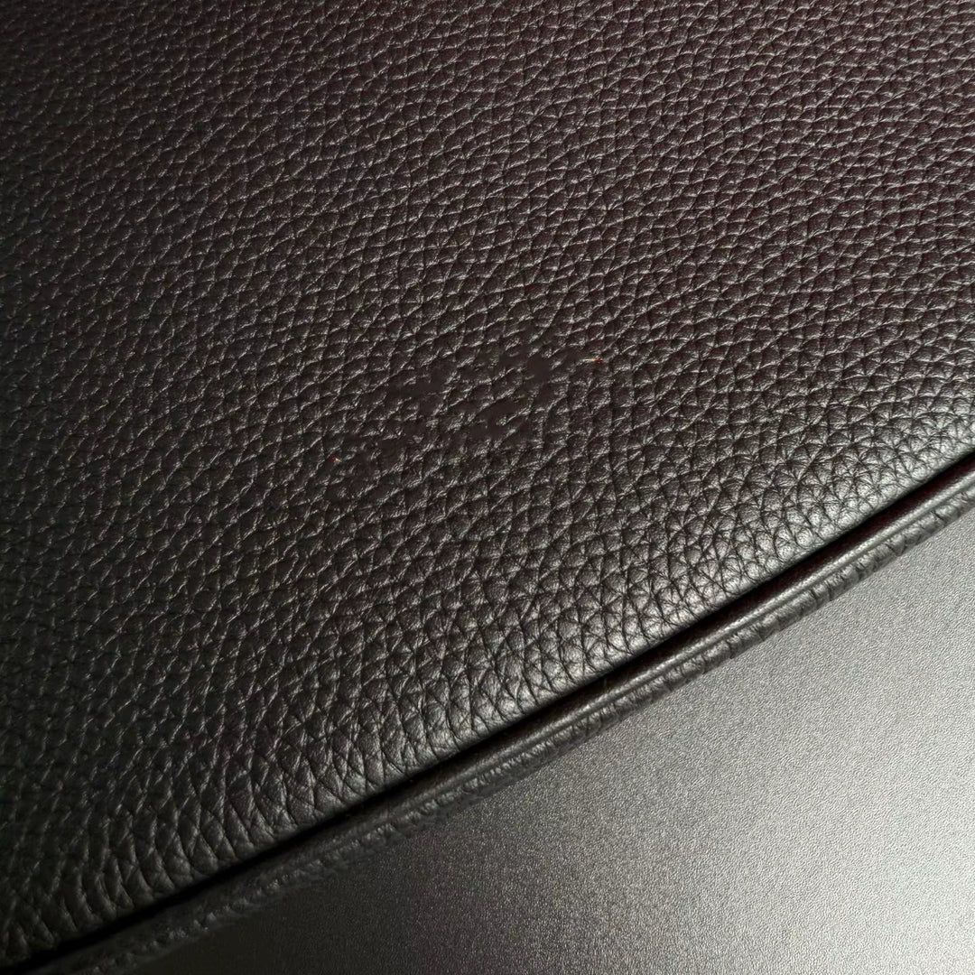 Close-up of dark brown leather surface with a light reflection