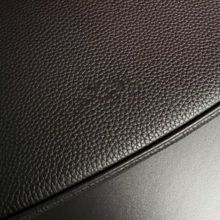 Close-up of dark brown leather surface with a light reflection