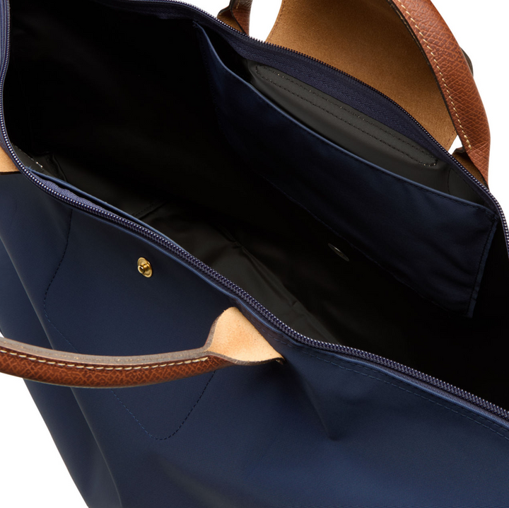 Navy tote bag with tan leather handles and trim