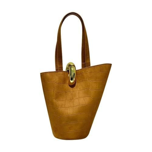 Olive green croc suede bucket bag with gold hardware on concrete table lifestyle shot