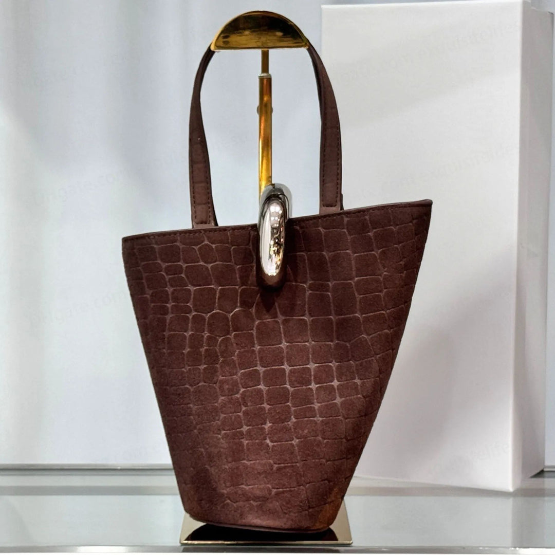 Small luxury suede bucket bag with double top handles and signature metal ring detail
