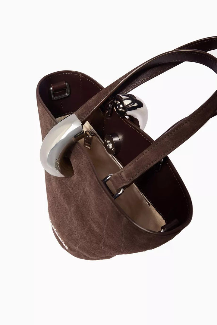 Small structured suede bucket bag side view with silver logo and hardware detail