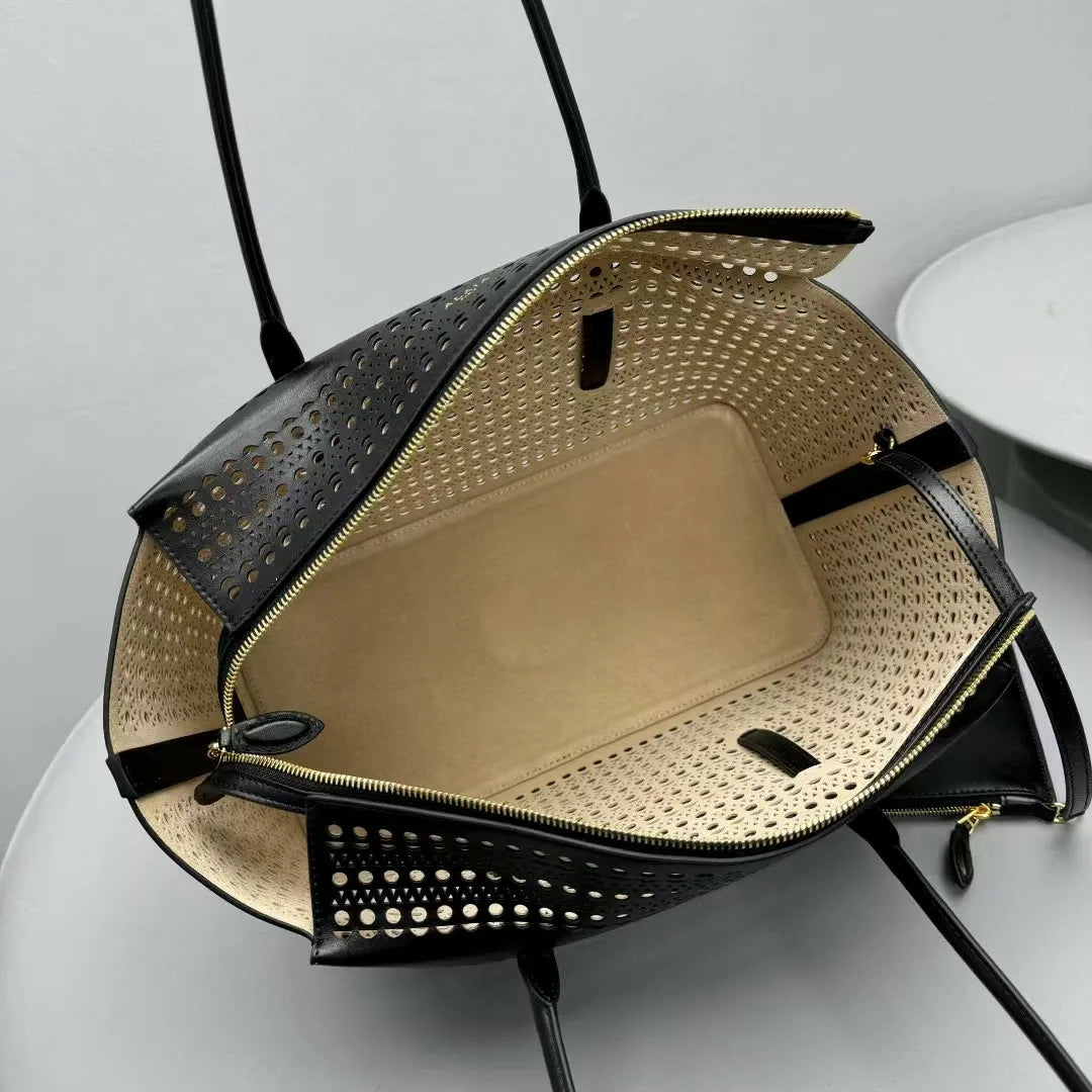 Black handbag with perforated design on a light gray background