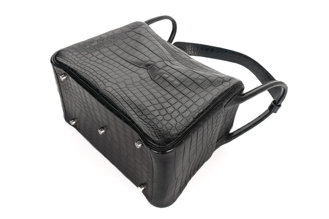 Black crocodile-patterned handbag on a white background