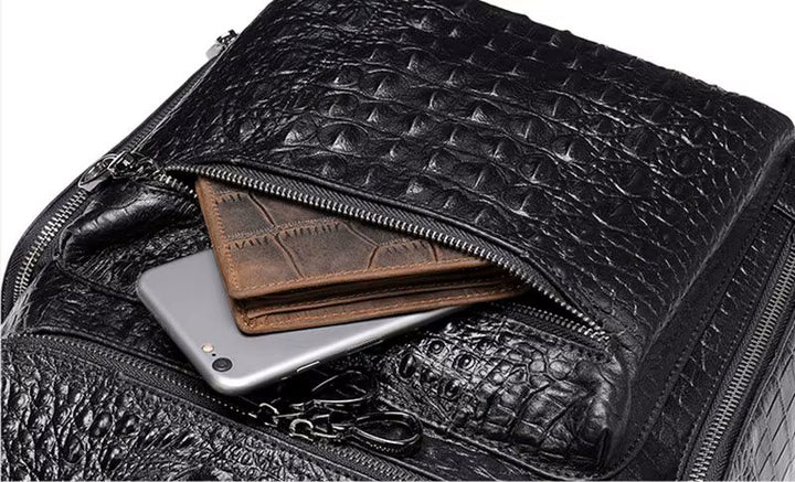 Brown alligator-embossed flap backpack angle view showing laptop compartment