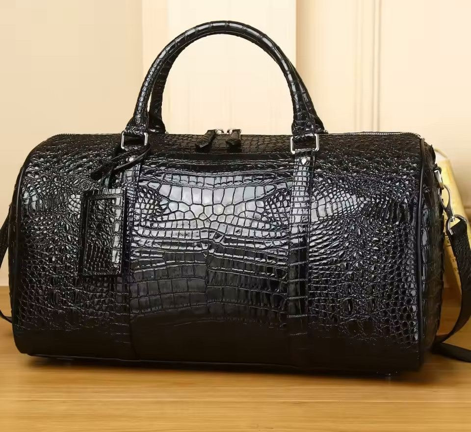 Croc-embossed leather travel duffle front view showing glossy 3D scale texture and zip closure
