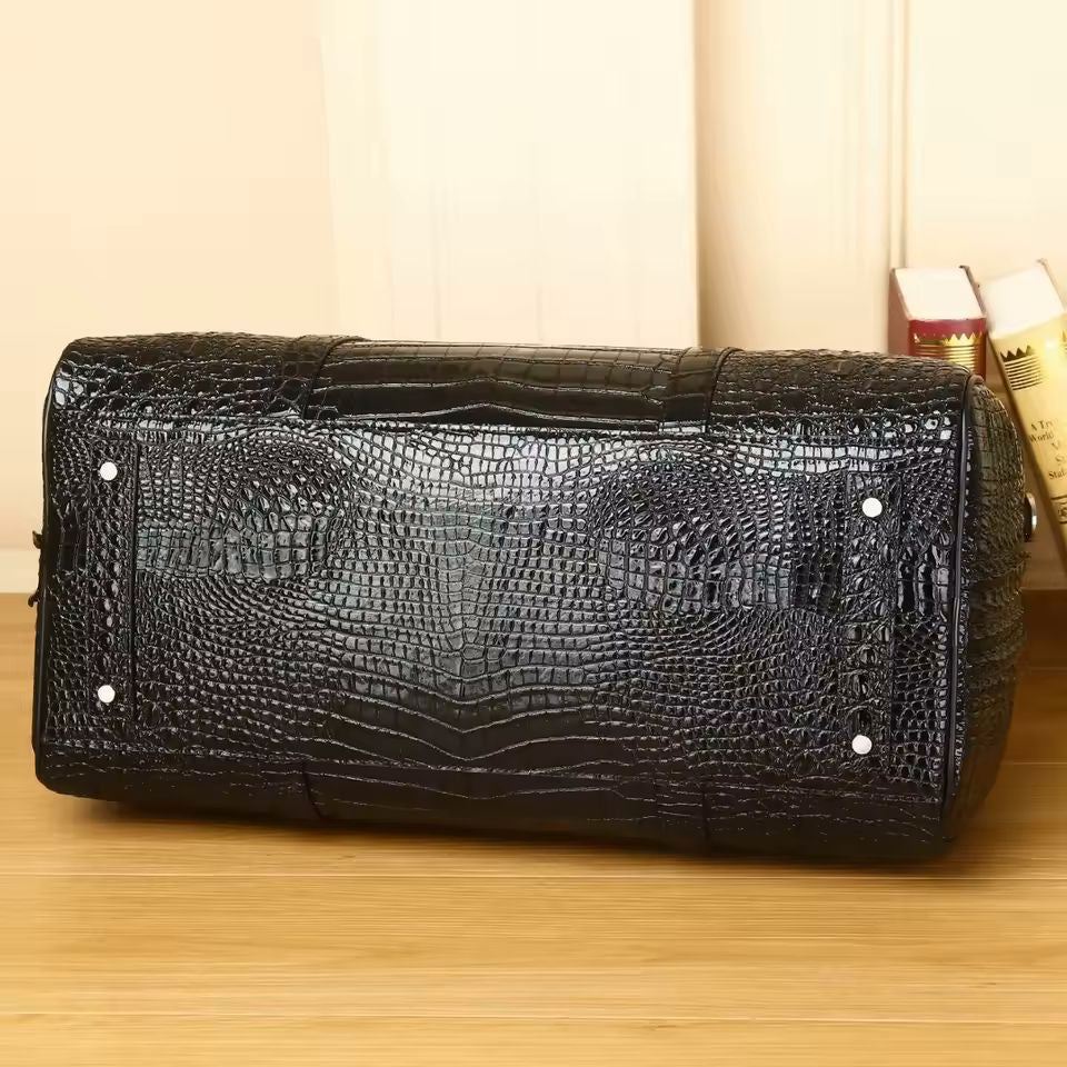 Black croc-embossed travel duffle lifestyle shot showing detachable shoulder strap detail

