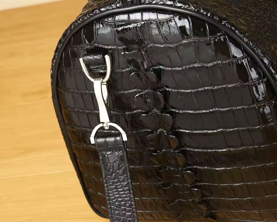 Croc-embossed leather duffle top view showing full-length zip closure and dual top handles
