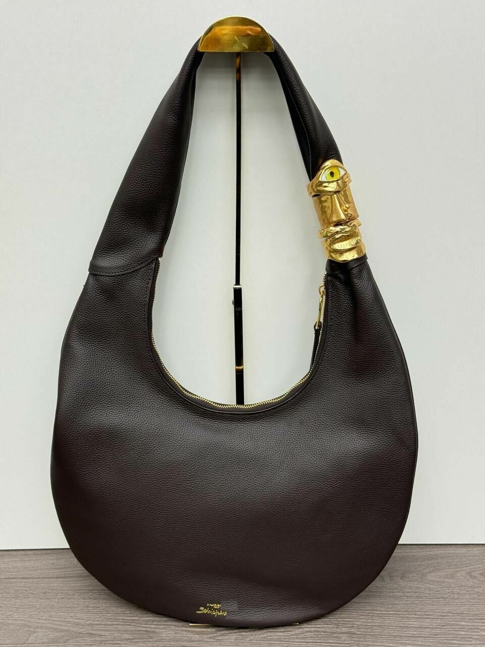Black handbag with gold accents on a light gray background