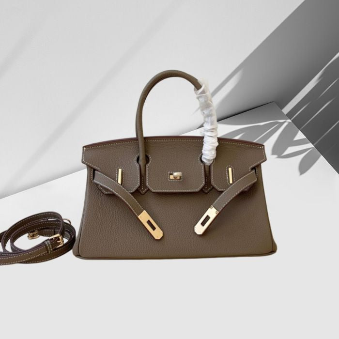 Brown handbag with gold hardware on a light gray background