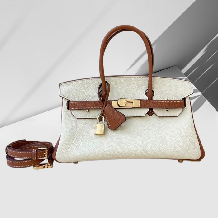 Premium full-grain leather tote bag base view showing feet and stitching detail