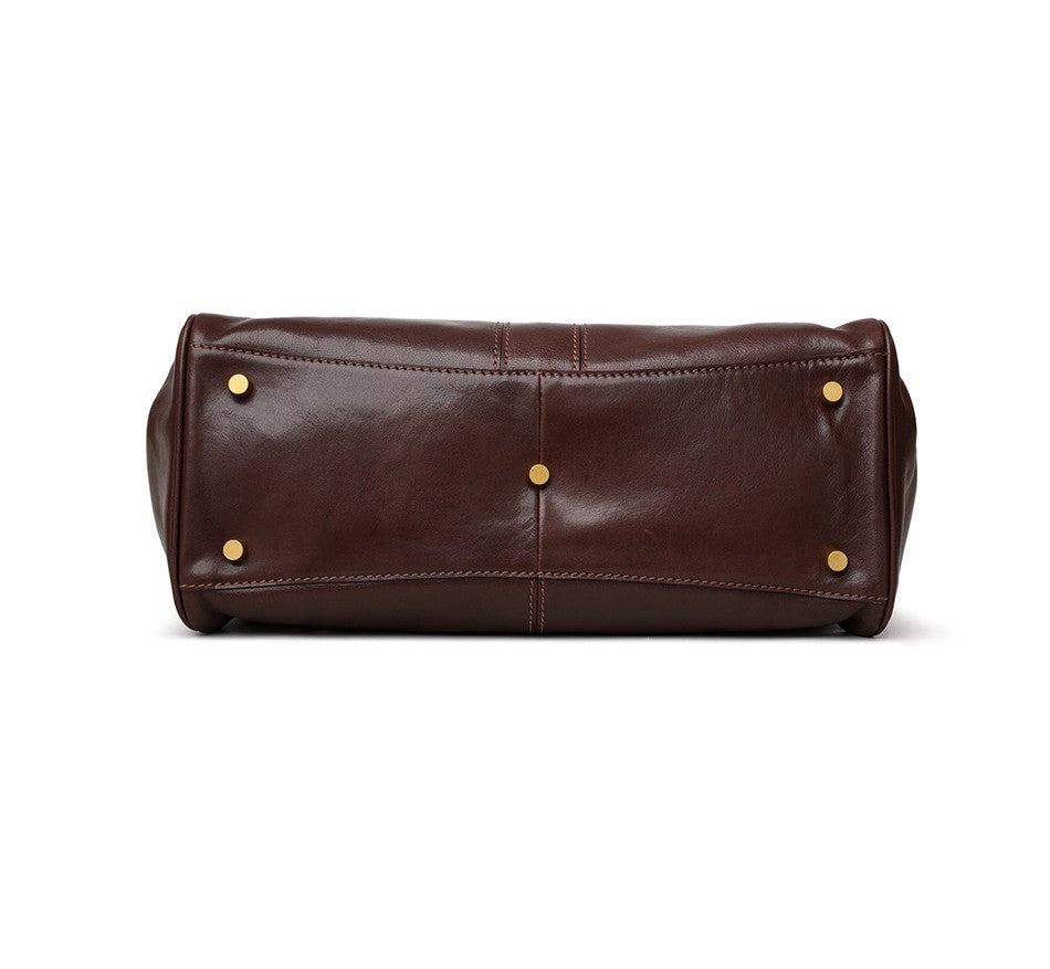 Brown leather toiletry bag with gold studs on a white background