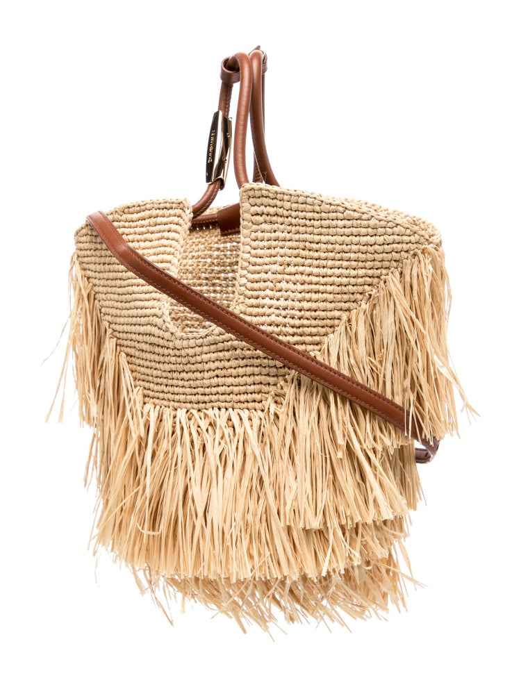 Woven handbag with fringes and brown leather straps on a white background