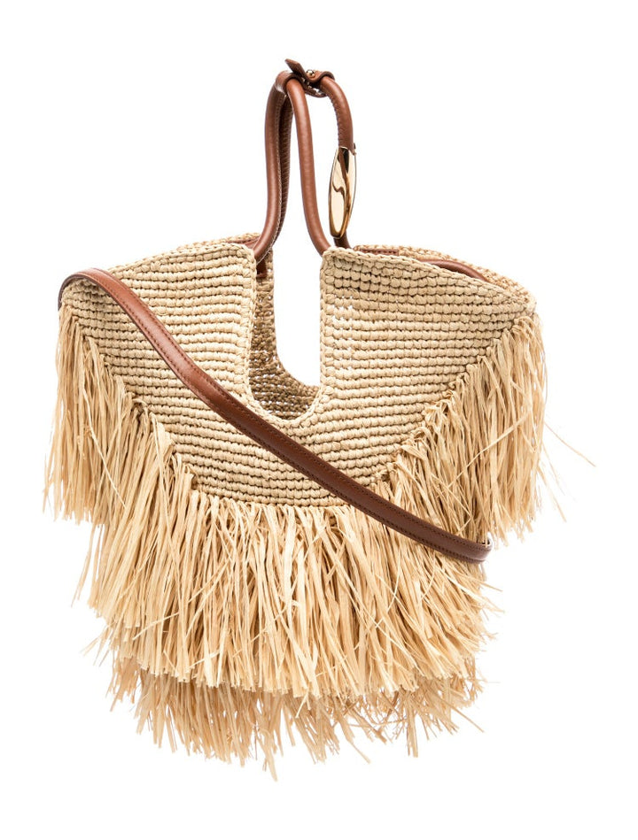 Woven handbag with fringe details and brown leather straps on a white background