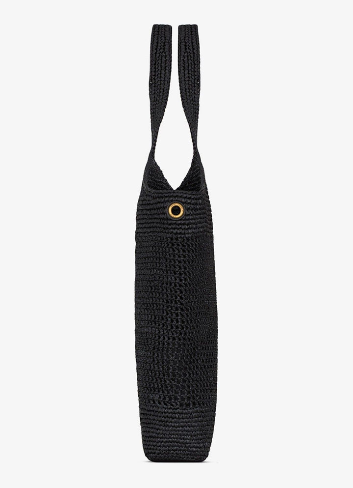 Large black raffia beach bag side view showing depth and open top silhouette