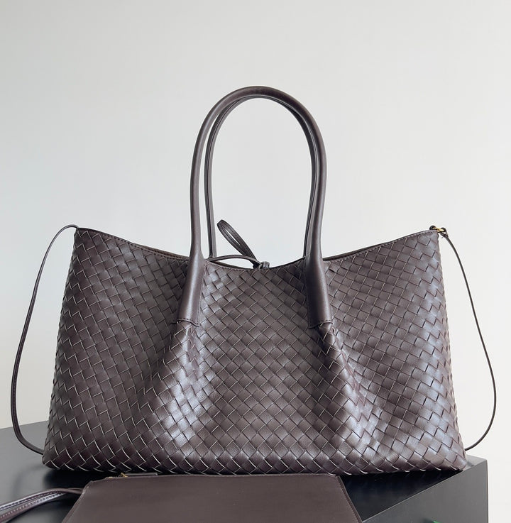 Large handwoven leather carryall in navy blue with soft structure and shoulder strap
