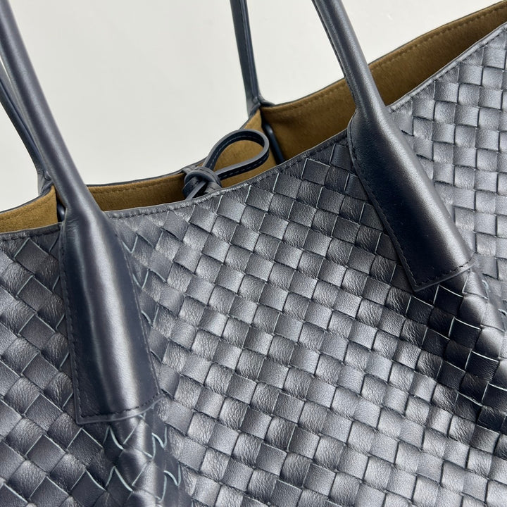 Dark brown woven leather tote bag with open top and long shoulder handles
