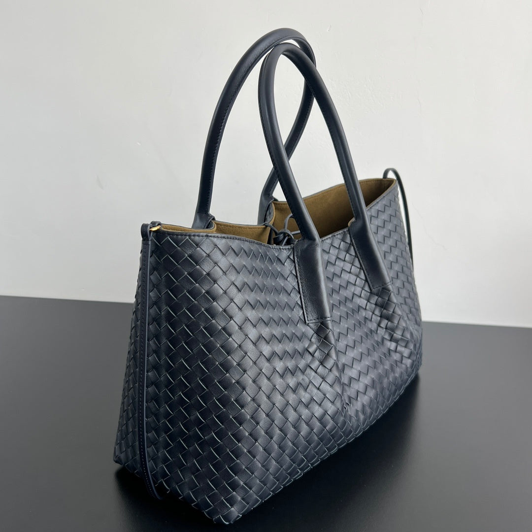 Large woven leather carryall bag front view with clean minimal silhouette