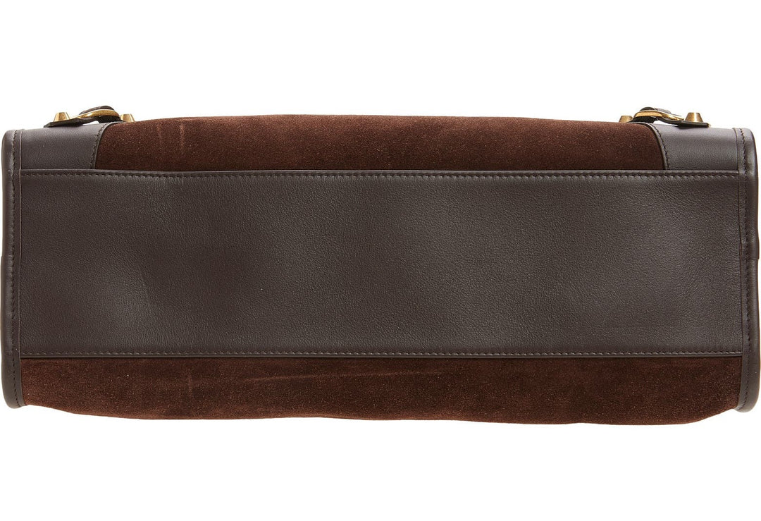 Brown leather bag with gold accents on a white background