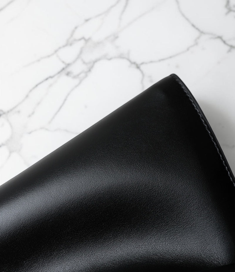 Black leather wallet on a marble surface